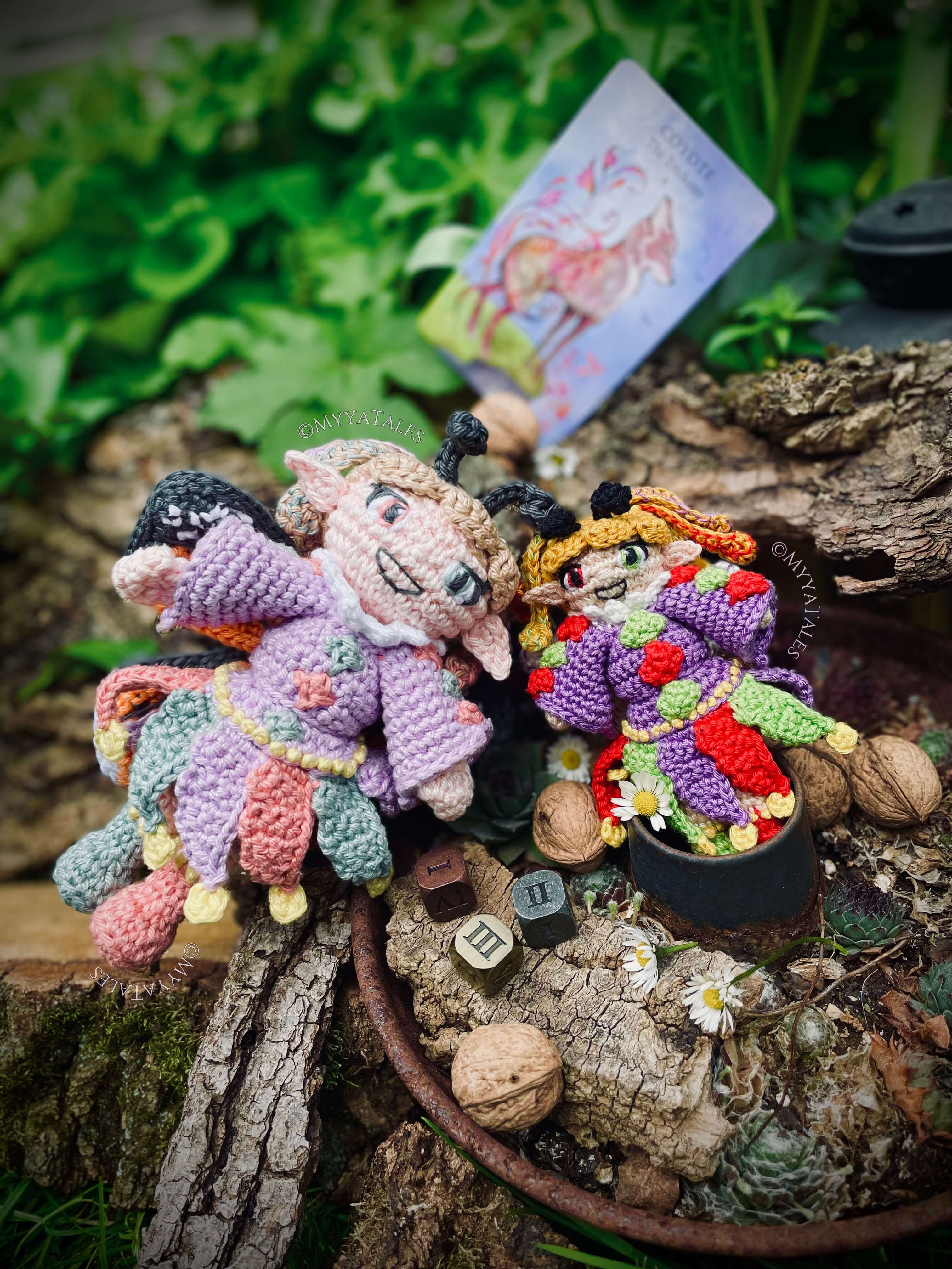 Two detailed, crocheted fantasy amigurumi dolls sitting in a goblincore setting against a tree bark backdrop for narrative crochet patterns by MyyaTales.